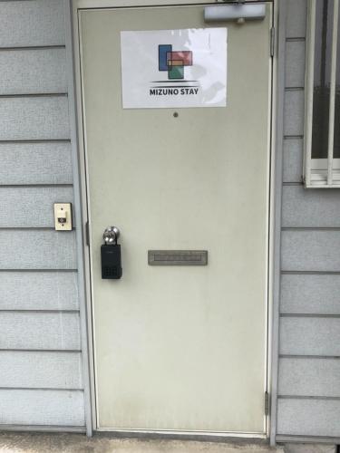 a door on a house with a sign on it at Chichibu Mizuno-stay 水野ステイ最大６名様 in Chichibu