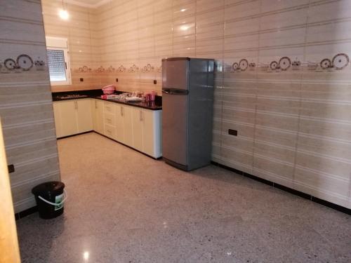 a kitchen with a stainless steel refrigerator in a room at Bokidan in Al Hoceïma