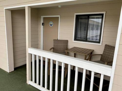 a porch with two chairs and a table and a window at Seaside Sanctuary Condo Villa - Private Beach Access, 3 Pools in Hilton Head Island
