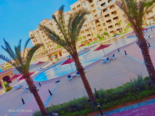 a view of a hotel with palm trees and a swimming pool at شالية استوديو 52 متر in Marsa Matruh