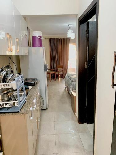 a kitchen with a refrigerator and a room with a table at شالية استوديو 52 متر in Marsa Matruh
