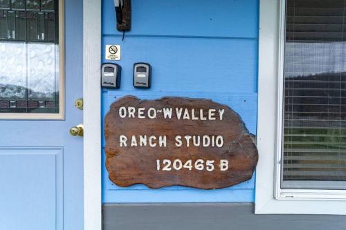 a sign on the door of a blue house at Elk Meadow Cabins Ranch Site Oreq-B in Orick