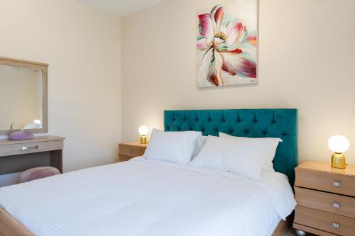 a bedroom with a large white bed with a blue headboard at namaste in Rhodes Town