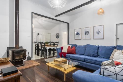 a living room with a blue couch and a fireplace at Family Fun Your beach and fishing delight in Rockingham
