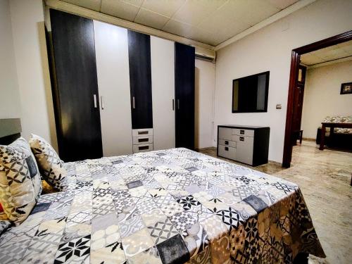 een slaapkamer met een bed met een quilt bij Apartamento El Rincón del Parque in Baena