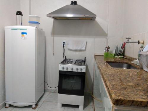 a small kitchen with a stove and a refrigerator at Recanto do Parque in Campo Grande