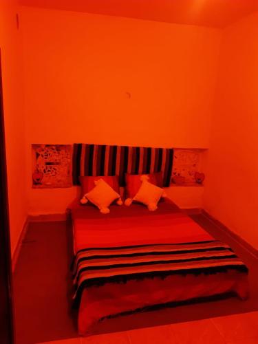 a red bedroom with a red bed with pillows at فرينة in Tafza