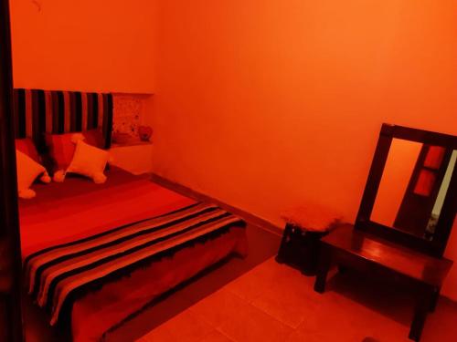 a red room with a bed and a mirror at فرينة in Tafza