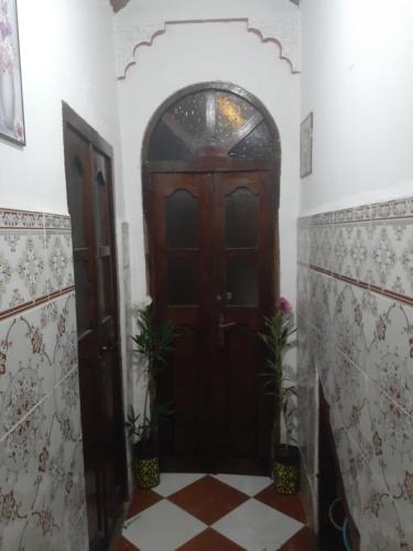 a wooden door in a room with a tile floor at فرينة in Tafza
