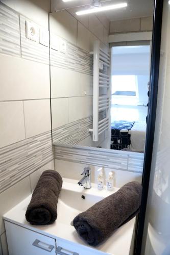 une salle de bain avec un lavabo et un miroir dans l'établissement Jupiter, à Saint-Quentin