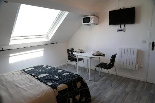 une chambre avec un lit et une table avec des chaises dans l'établissement Jupiter, à Saint-Quentin
