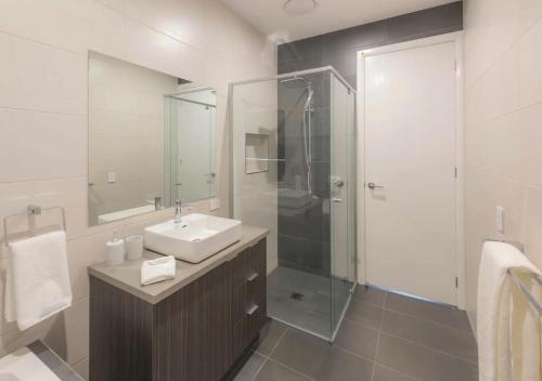 a bathroom with a sink and a glass shower at NEW - Sunrise Waters Holiday House in Mulwala
