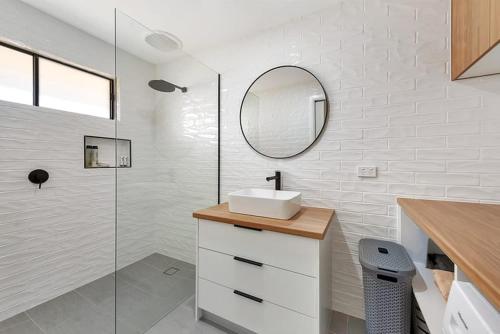 a white bathroom with a sink and a mirror at Lakeside Apartment on Pool Avenue in Mulwala