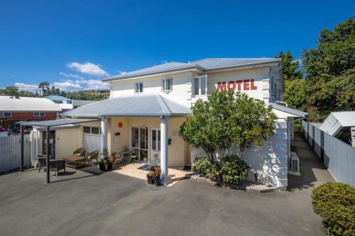 a house with a hotel sign on the front of it at Boutique Motel in Nelson