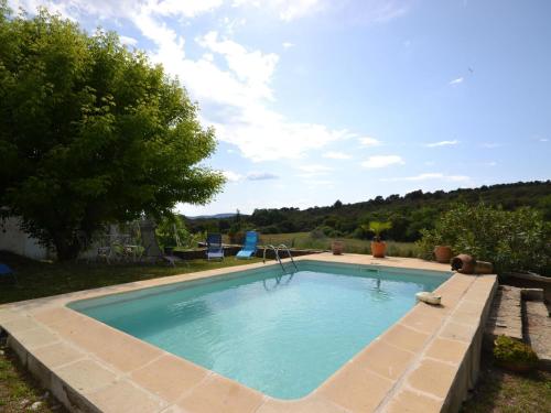 a swimming pool in a yard with a brick wall at Flat with private pool in the heart of nature in Malaucène