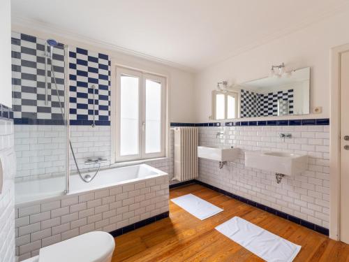 ein Badezimmer mit zwei Waschbecken, einer Badewanne und einem WC in der Unterkunft Historic building with a high level of finishing in Borgloon in Borgloon
