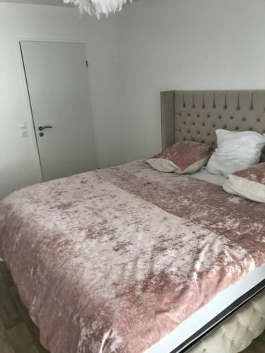 een slaapkamer met een bed met een roze deken bij T2 de standing proche centre ville in Caen
