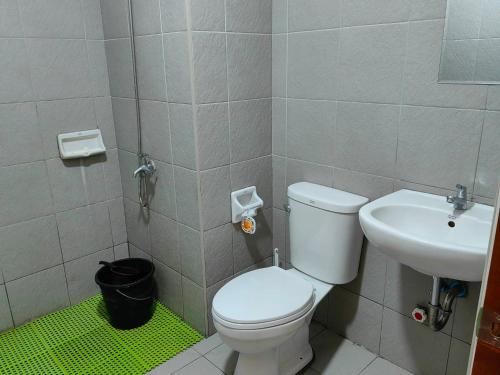 y baño con aseo blanco y lavamanos. en Mesatierra Garden Residences - Condo en Davao