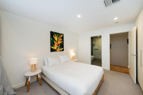 Un dormitorio blanco con una cama blanca y una lámpara en Accommodate Canberra - Canberra 22, en Kingston 