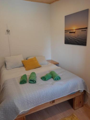a bedroom with a bed with two green slippers on it at Nadadouro Eco-country-cottage in Nadadouro