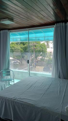 1 dormitorio con cama y ventana grande en Pousada Beira Litoral, en João Pessoa