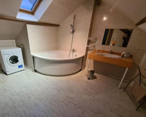 a bathroom with a tub and a washing machine at duplex spacieux Jo24 proche Paris et stade de France in Drancy