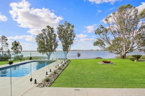 una piscina en un parque junto a un cuerpo de agua en Waterview Place Holiday House, en Yarrawonga