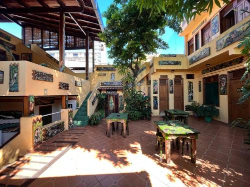 Hostel Manaus في ماناوس: مبنى به مقاعد وطاولات في ساحة الفناء