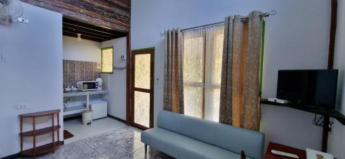 a living room with a blue couch and a television at Korp View House in Wang Nam Khieo