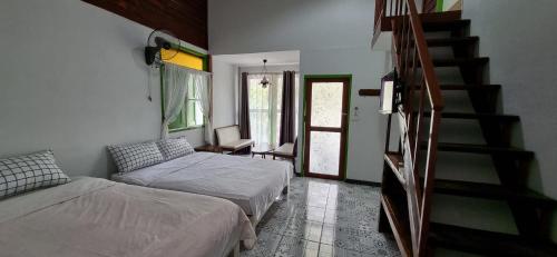 1 dormitorio con 2 camas y escalera en Korp View House, en Wang Nam Khiao