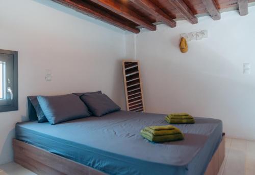 a bedroom with a large bed with blue sheets at Traditional villa in Sifnos