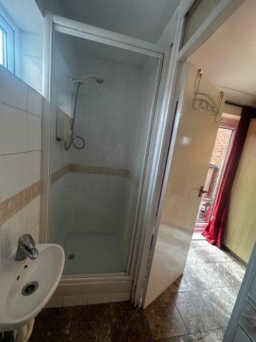 a bathroom with a shower and a sink at Heathrow28 in West Drayton