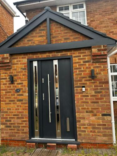 a black front door of a brick house at Heathrow28 in West Drayton