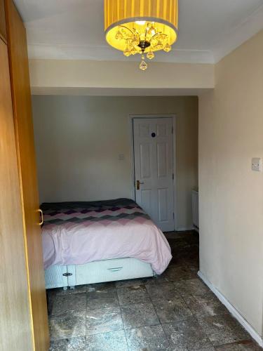 a bedroom with a bed and a chandelier at Heathrow28 in West Drayton