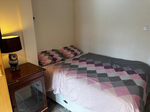 a small bedroom with a bed and a table at Heathrow28 in West Drayton