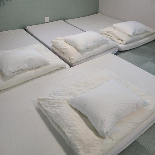 drie bedden met witte lakens en kussens in een kamer bij Fluctus - Vacation STAY 16974v in Hitachi