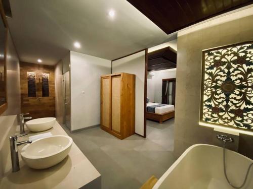 y baño con 2 lavabos y bañera. en Villa Dewa Dewi 2, en Ubud