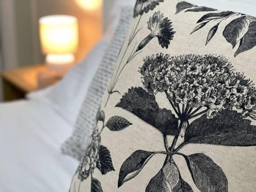 a pillow with a black and white flower pattern on it at LAHOOL GUEST HOUSE JUST A CREEKSIDE STROLL TO TOWN in Stanthorpe