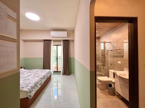 um quarto com uma cama e uma casa de banho com um lavatório em T-HOUSE em Taitung City