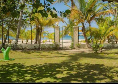 a park with a gate and palm trees on the beach at EL Bonito II Juan Dolio DR 2 room sleeps6 1queen bed 2twin bed 1sofa bed in Juan Dolio