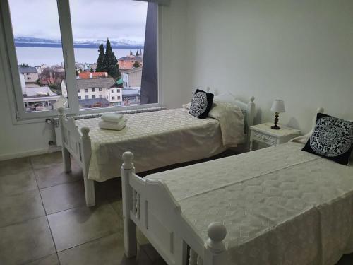 1 Schlafzimmer mit 2 Betten und einem großen Fenster in der Unterkunft Arrayan in San Carlos de Bariloche