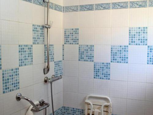 uma casa de banho com um chuveiro com azulejos azuis e brancos em Gîte Croisilles, 5 pièces, 7 personnes - FR-1-376-63 em Croisilles