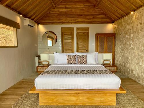 um quarto com uma cama grande num quarto em KERTASARI LODGE em Lemonga