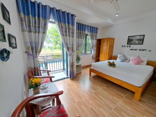 sypialnia z łóżkiem i dużym oknem w obiekcie GREEN TOWN hotel HỘI AN w Hoi An