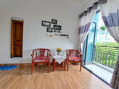 een eetkamer met een tafel en 2 stoelen en een raam bij GREEN TOWN hotel HỘI AN in Hội An