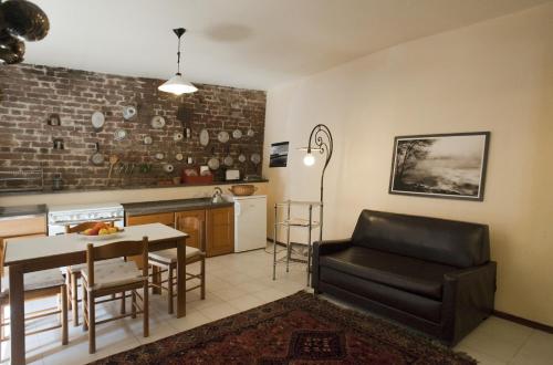 維傑瓦諾的住宿－索托艾梅利公寓，厨房以及带桌子和沙发的客厅。