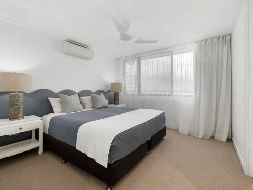 a bedroom with a large bed and a window at Luxury with lake and hinterland views in Noosa Heads
