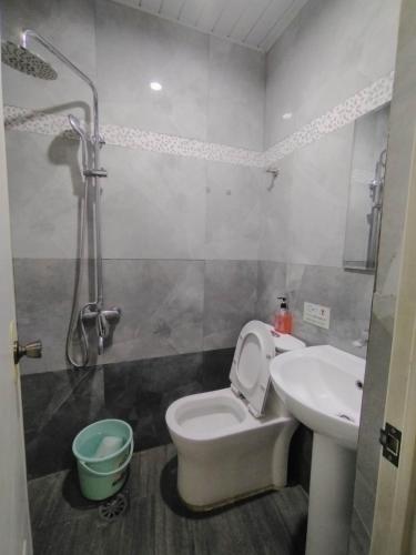 a bathroom with a toilet and a sink and a shower at Quirino Hub (401) in Davao City