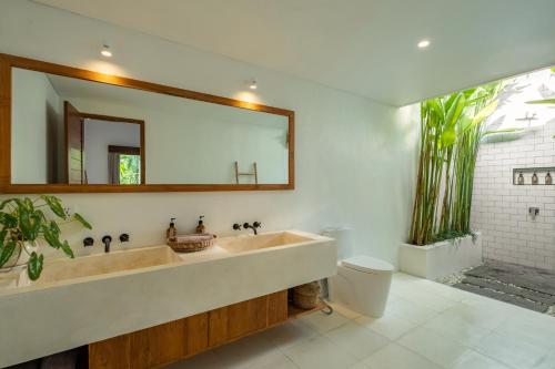 a bathroom with a large sink and a mirror at Blue Door Villa, Central Canggu in Canggu