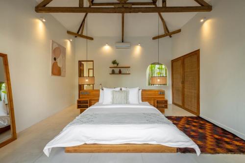 a bedroom with a large bed with white sheets at Blue Door Villa, Central Canggu in Canggu